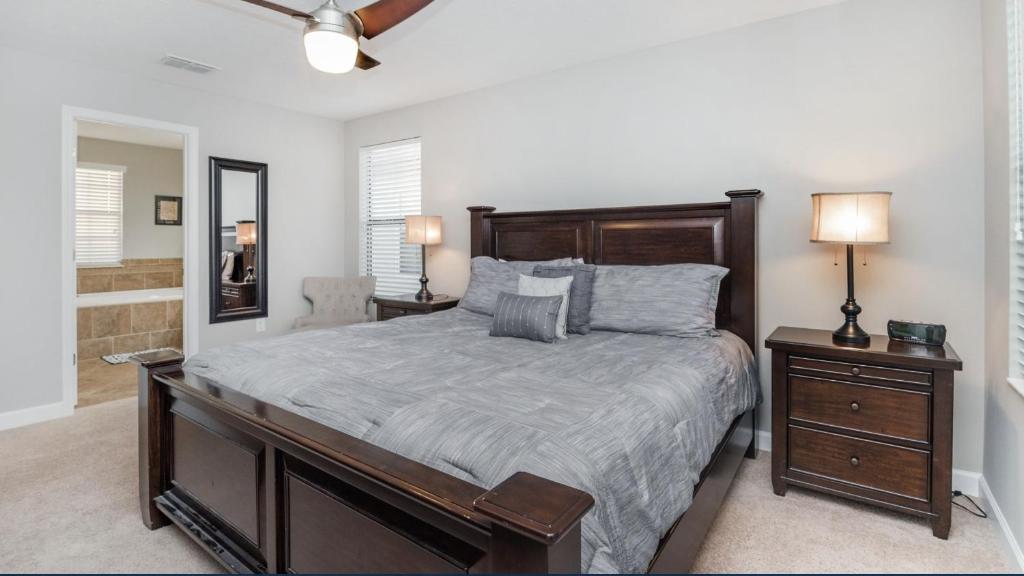 a bedroom with a large bed and a night stand at Elegant Andrew Pool Home in Davenport