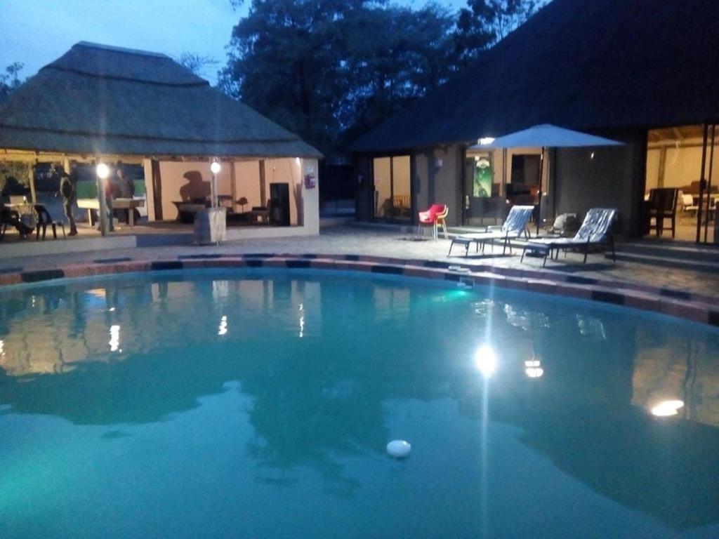 a large swimming pool in a yard at night at LEHAE BNB in Mbabat