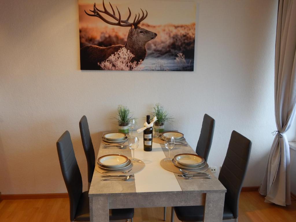 uma mesa de jantar com uma pintura de veado na parede em Appartement zur Bergoase mi Schwimmbad em Hohegeiß