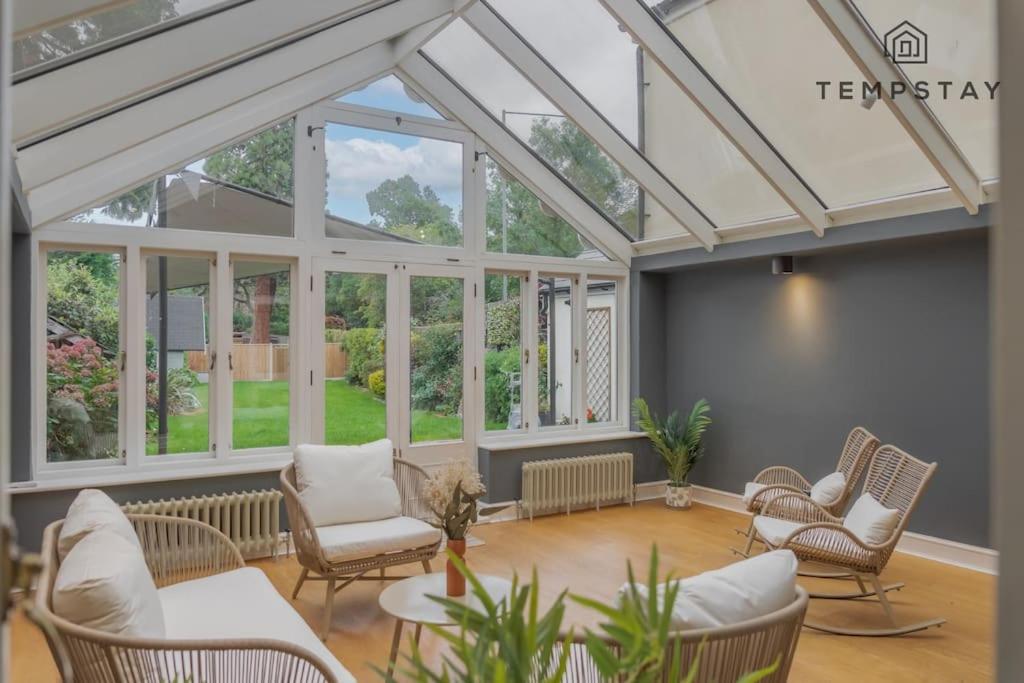 an empty living room with a conservatory with windows at Cosy Family Home Near Thorpe Park & Legoland in Old Windsor