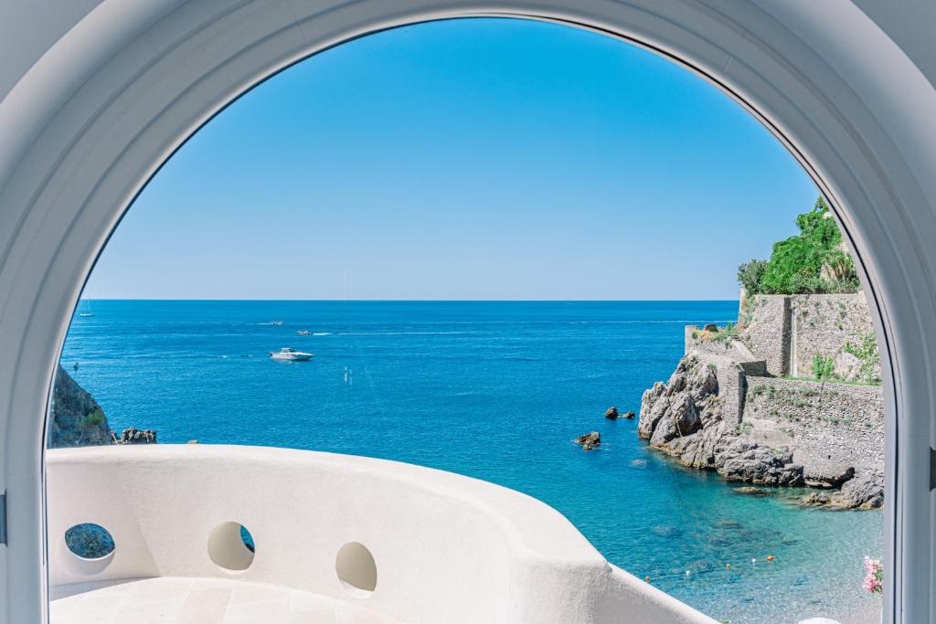 a view of the ocean through an archway at Acquachiara Seaside Luxury Villa in Amalfi Coast in Maiori