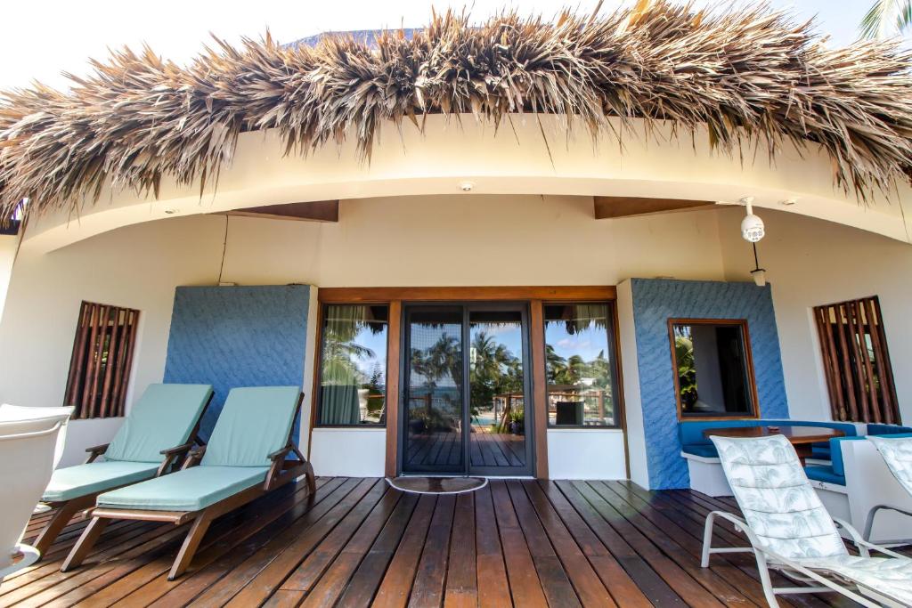 a resort with chairs and a thatched roof at La Perla del Caribe - Villa Jade in San Pedro
