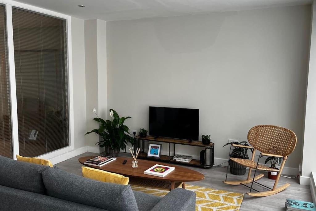ein Wohnzimmer mit einem Sofa und einem Tisch in der Unterkunft Lovely 1-bedroom apartment in London N1 in London