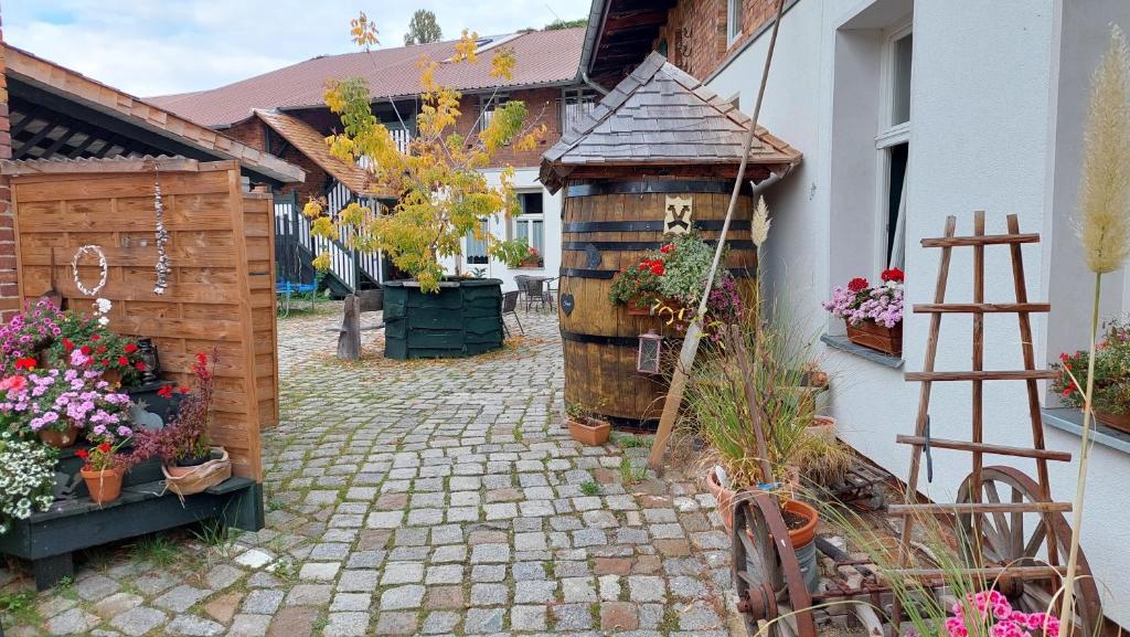 einen Innenhof mit einem Garten mit Blumen und einem Gebäude in der Unterkunft Spreewald Spreemilia Gurkenbude in Lübbenau