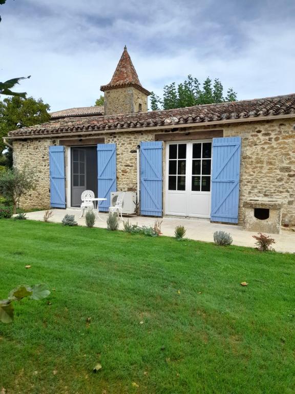 Casa de piedra con puertas azules y patio en La petite maison bleue avec piscine en Loubejac