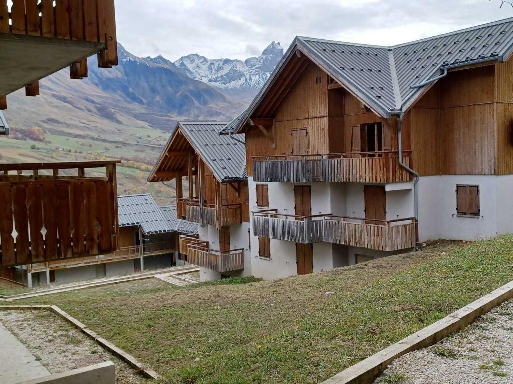 a row of wooden buildings with mountains in the background at Appartement Albiez-Montrond, 2 pièces, 6 personnes - FR-1-618-19 in Albiez-Montrond