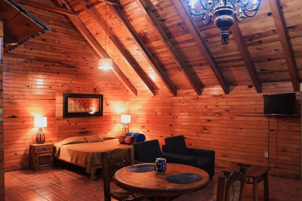 a bedroom with a bed and a table in a room at La Huerta in Mazamitla