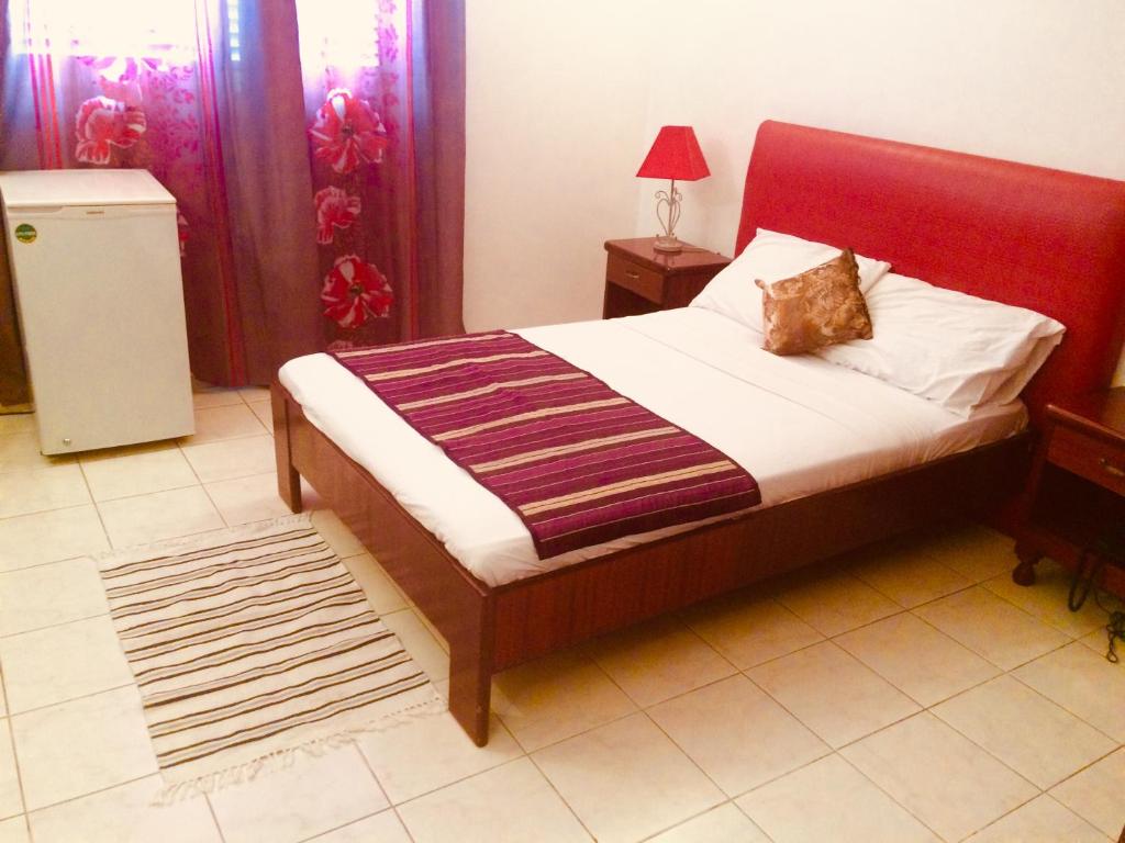 a bedroom with a bed with a red headboard at HOTEL ALIA in Djibouti