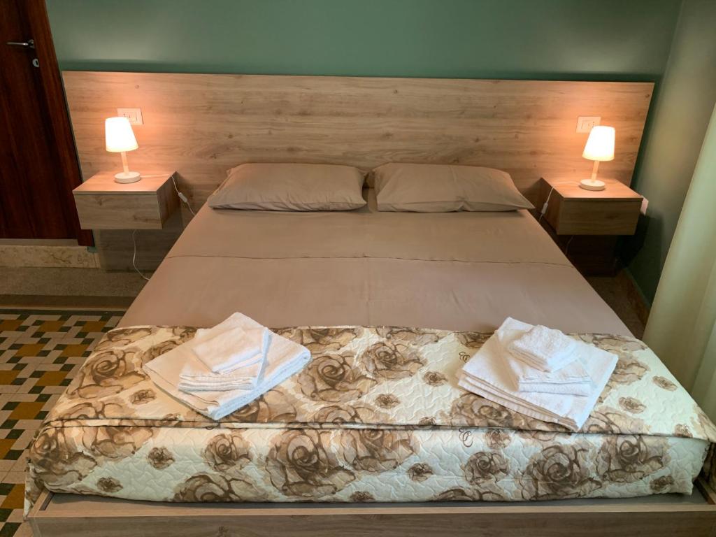 レッジョ・ディ・カラブリアにあるErythrà Bed and Breakfastのベッドルーム1室(ベッド2台、ランプ2つ付)