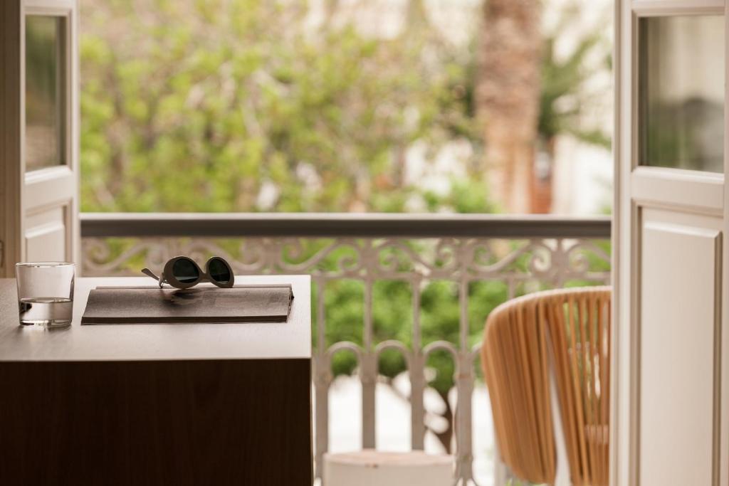 a pair of glasses sitting on a table in front of a window at SYROS SOUL LUXURY SUITES in Ermoupoli