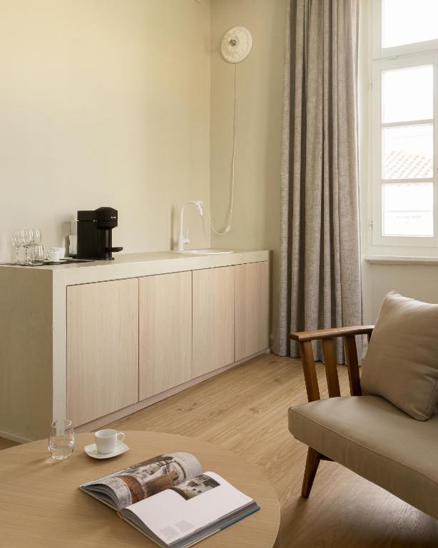 a living room with a table and a chair at SYROS SOUL LUXURY SUITES in Ermoupoli