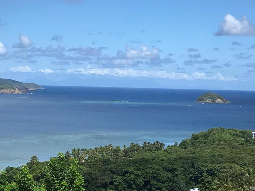una vista del océano con islas a lo lejos en Top Hill appartements et dortoir - Martinique, en La Trinité