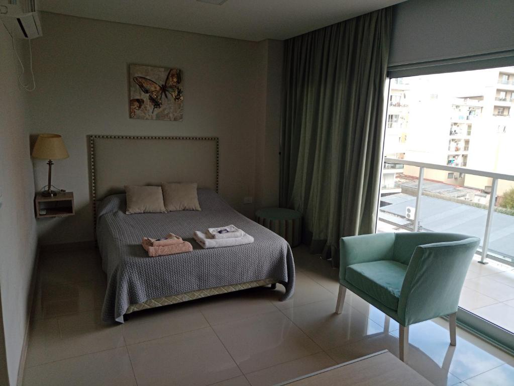 a bedroom with a bed and a chair and a window at TORRE GUAYASAMIN in Corrientes