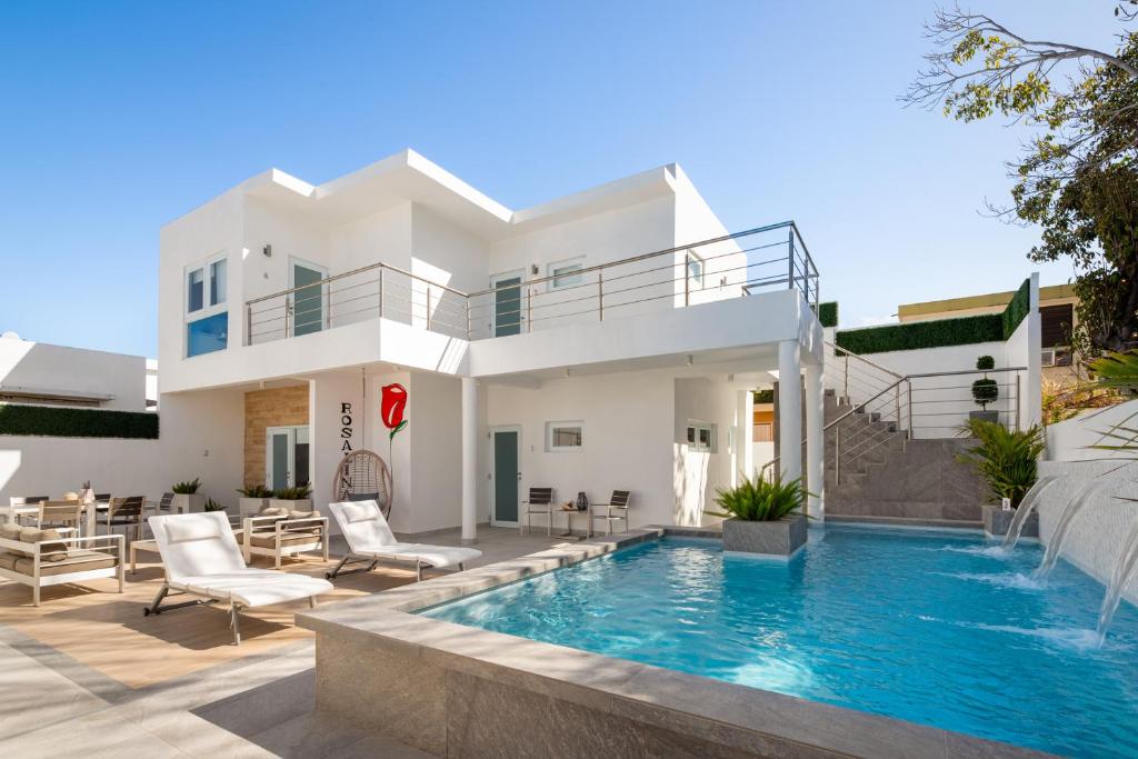 uma villa com piscina em frente a uma casa em Rosalina Ocean Park em San Juan