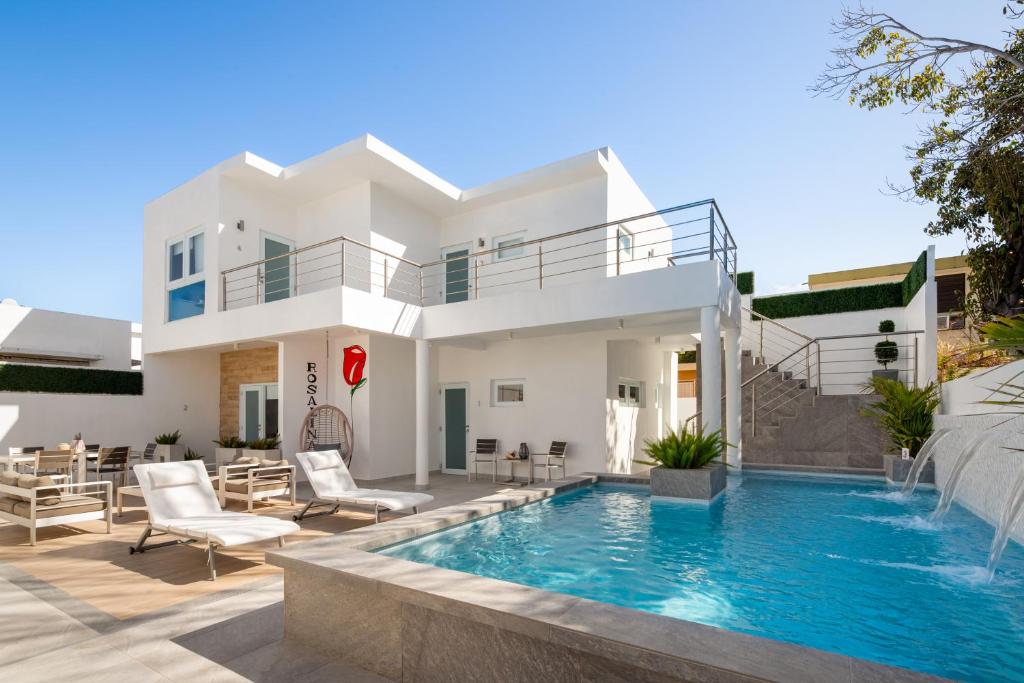 a villa with a swimming pool in front of a house at Rosalina Ocean Park in San Juan