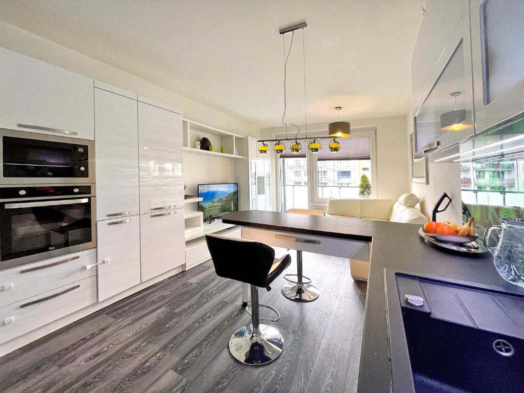 eine Küche mit weißen Schränken und einer schwarzen Arbeitsplatte in der Unterkunft British Quarter Apartments in Prag