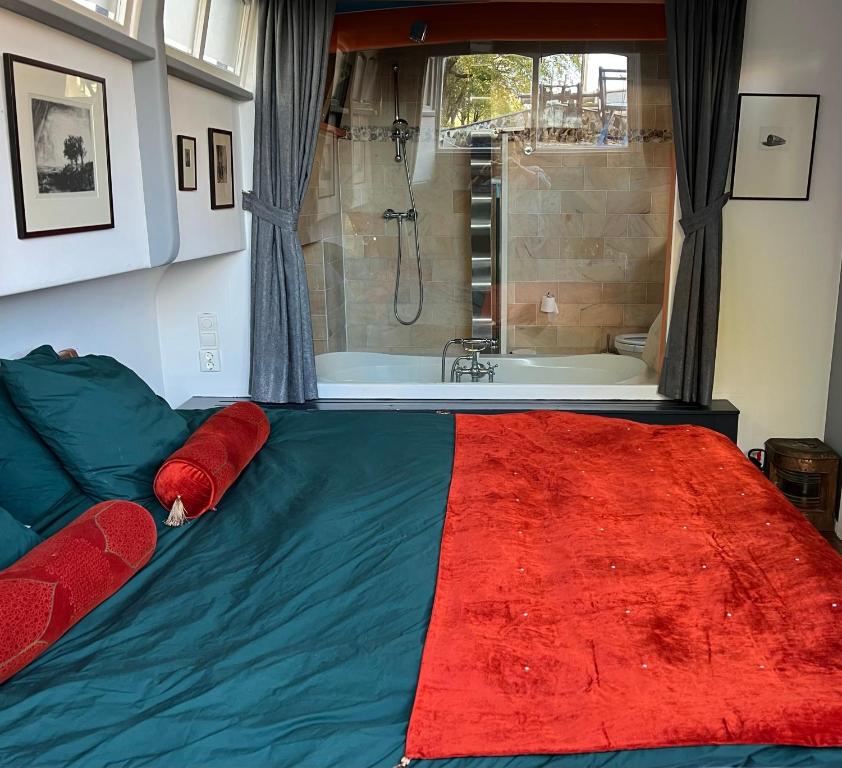 - une chambre avec un grand lit et une baignoire dans l'établissement Amsterdam Center - Houseboat B&B by Captain Ricard, à Amsterdam