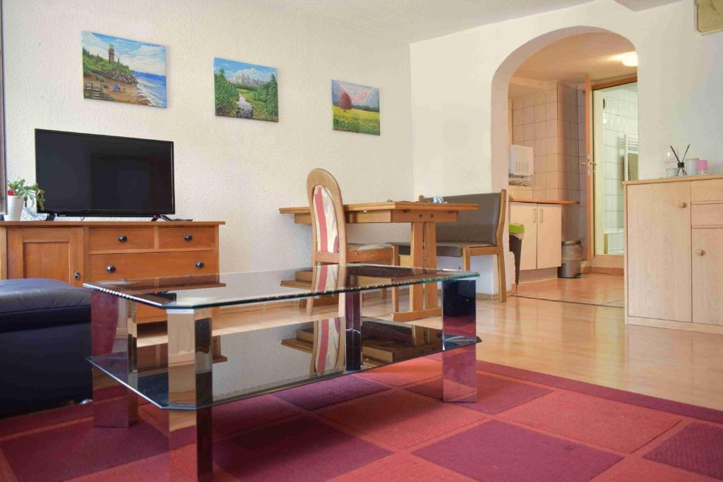 カルフにあるFerienwohnung Hermann Hesse Stadtのリビングルーム(ガラステーブル、テレビ付)
