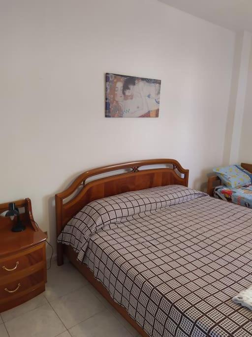 sypialnia z łóżkiem i komodą z obrazem na ścianie w obiekcie Casa graziosa con ampio cortile per i tuoi momenti all'aperto w mieście Alghero