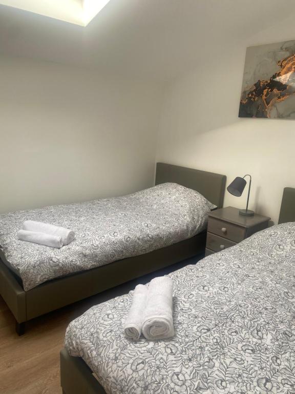 a room with two beds with towels on them at Town Centre Apartment in Leek