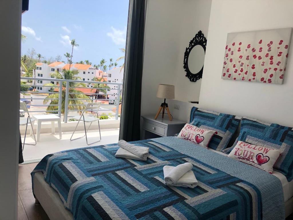 a bedroom with a bed with a view of a balcony at Ducassi Sol Caribe Beach in Punta Cana