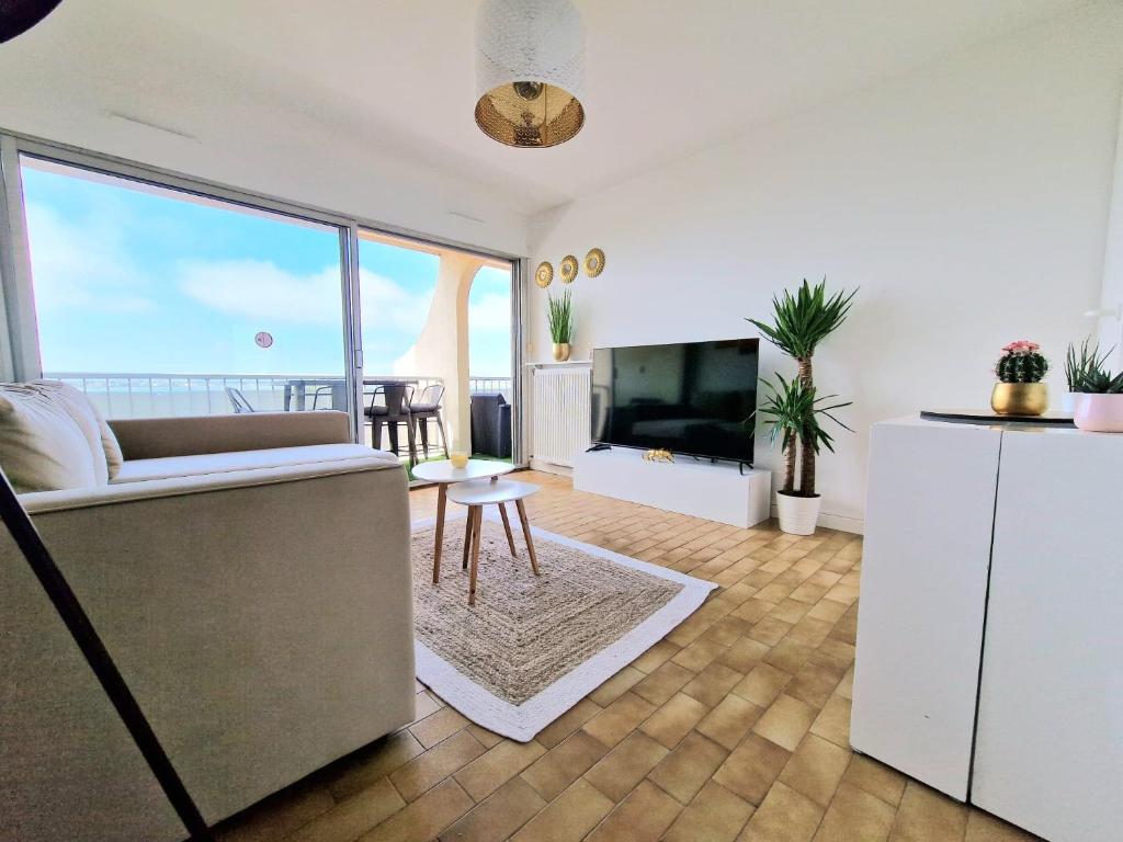 Televízia a/alebo spoločenská miestnosť v ubytovaní Appartement 1ere ligne piscine terrasse au bord de la plage front de mer avec 6 vélos