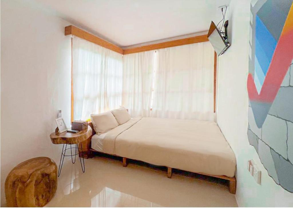 um pequeno quarto com uma cama e uma janela em Danka Vacation Home em Seribu