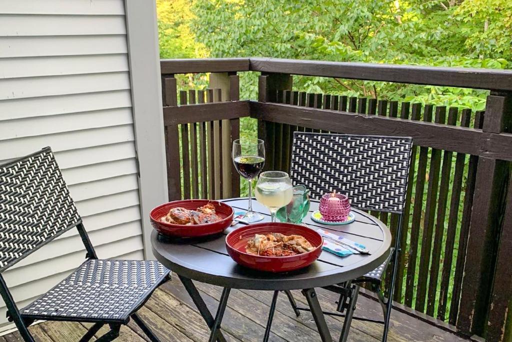 una mesa con dos tazones de comida y una copa de vino en Sunrise: West Glade-H2 en South Sherburne
