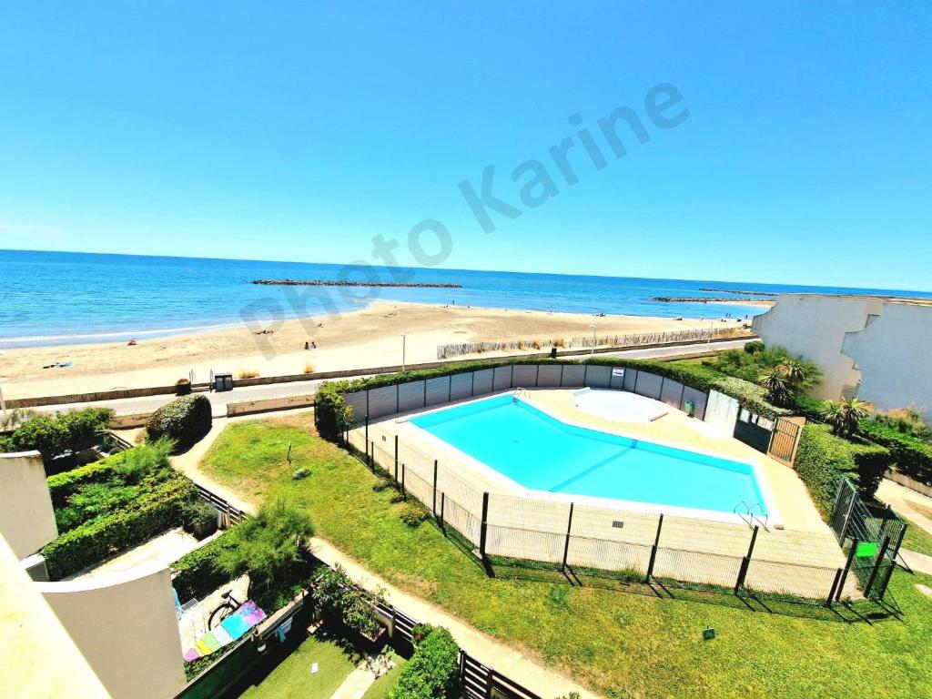 Изглед към басейн в Appartement 1ere ligne piscine terrasse au bord de la plage front de mer avec 6 vélos или наблизо