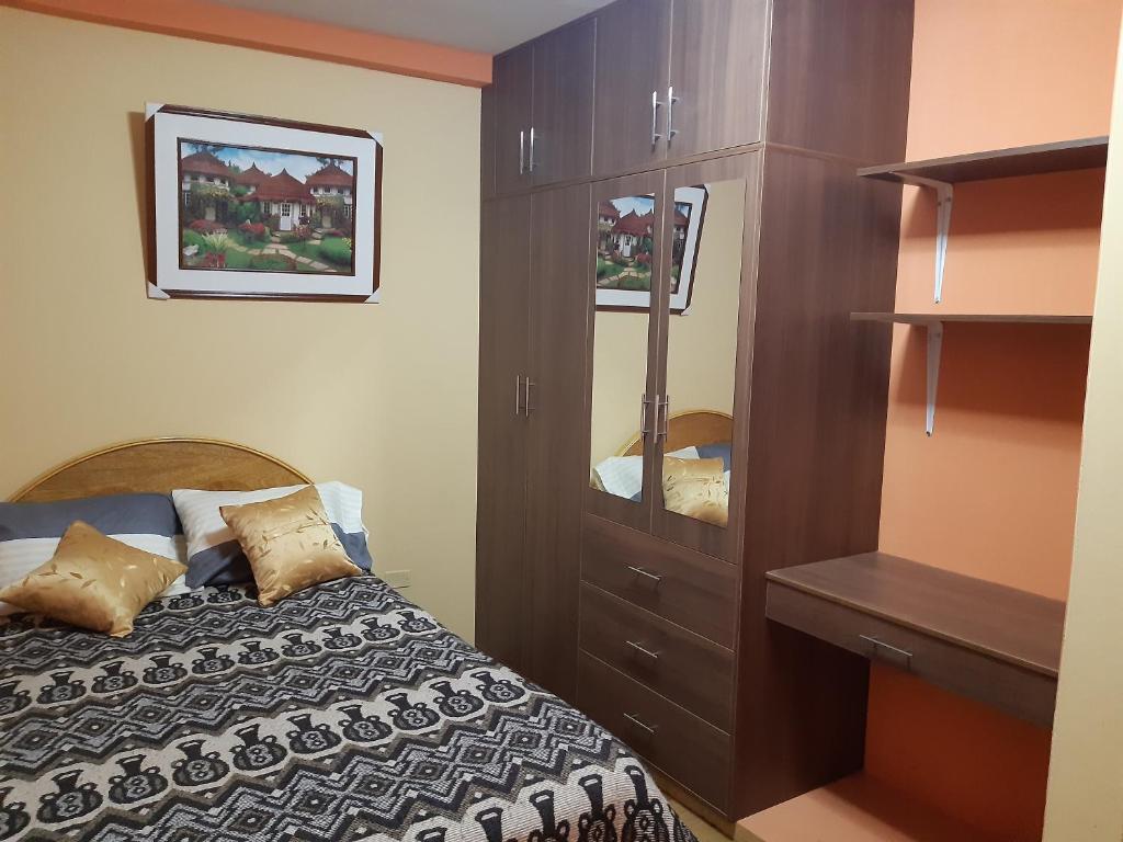 1 dormitorio con 1 cama y armario de madera en Hostal Vista al Lago Titicaca Puno en Puno