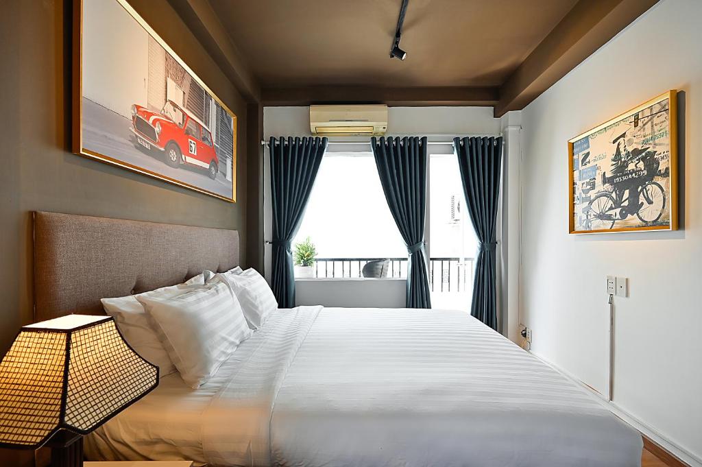 a bedroom with a large white bed with a window at The Noble Swan Wood Park Hotel in Ho Chi Minh City