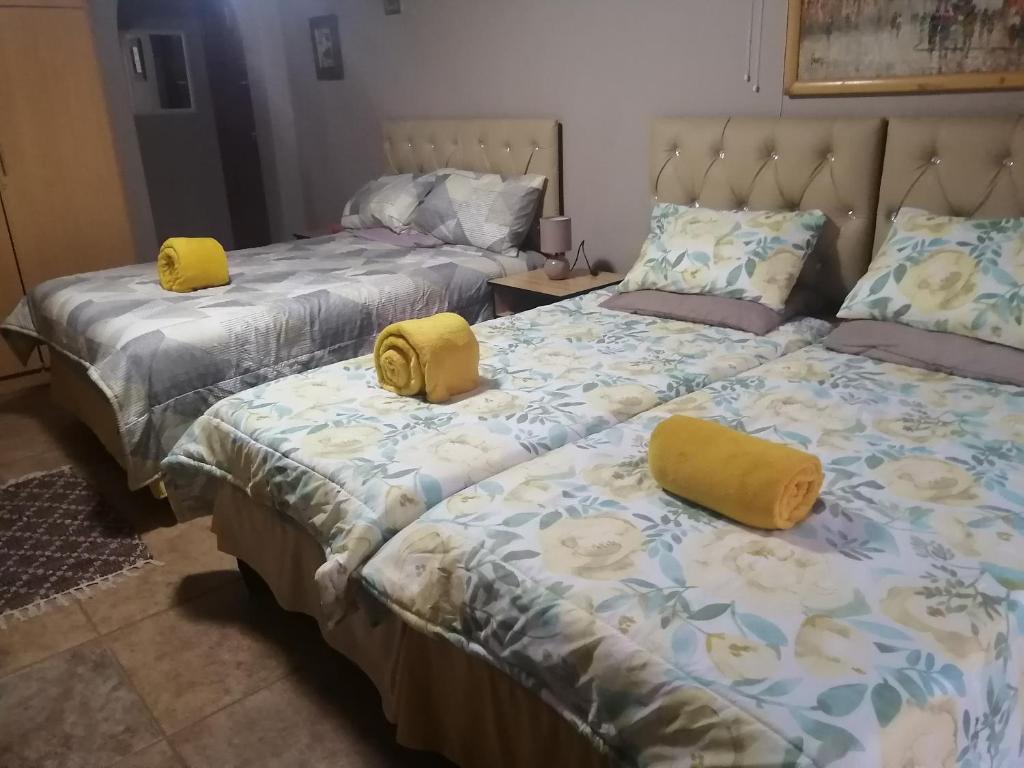 - 2 lits avec des oreillers jaunes dans une chambre dans l'établissement Grace's Santuary, à La Mercy