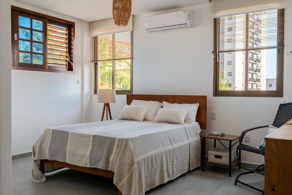 卡貝德盧的住宿－Casa de Praia Areia Vermelha，一间卧室配有一张床、一把椅子和窗户。