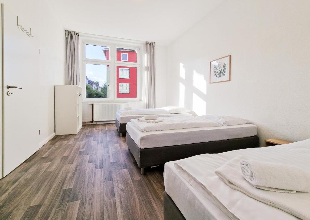 una camera con tre letti e una finestra di RAJ Living - 1 Room Monteur Apartments - 25 Min Messe DUS a Duisburg