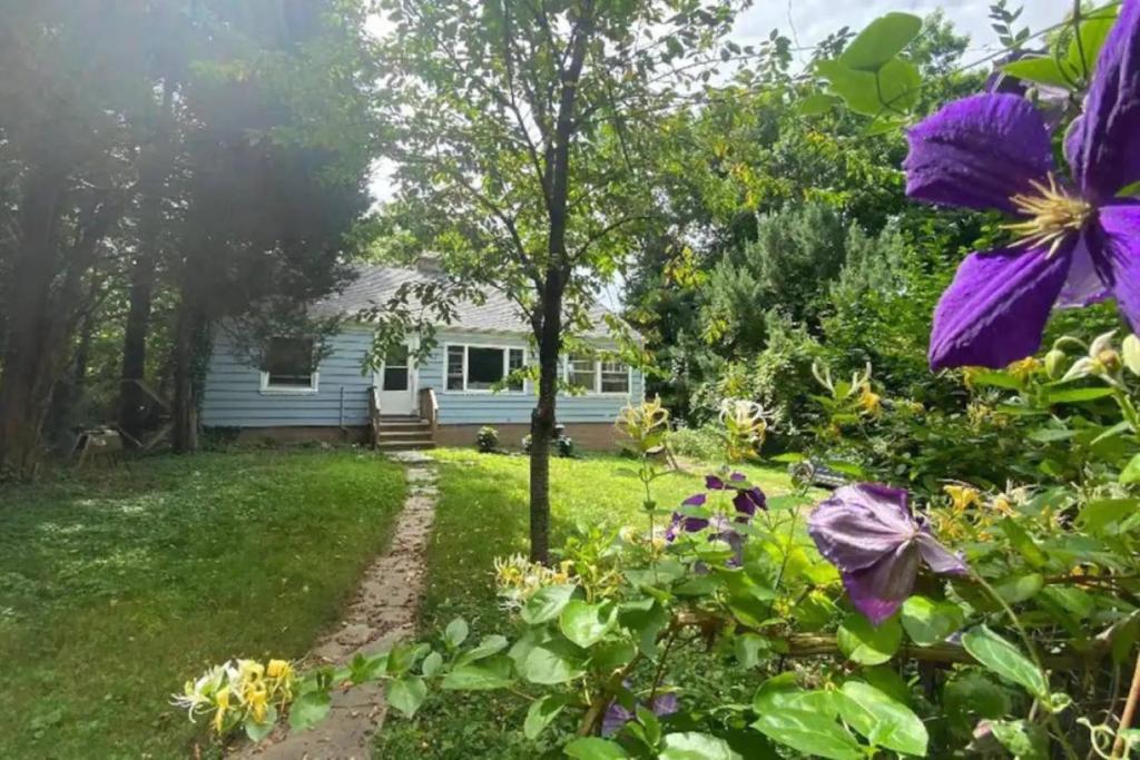 una vista de una casa desde el patio con flores en Cedar Ridge Cottage, en Guilford