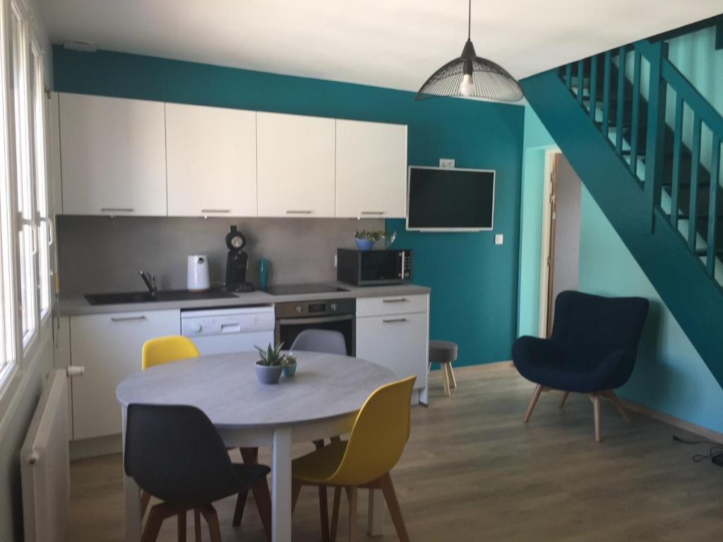 a kitchen with a table and chairs in a room at Bel appartement duplex L'OPALE classé 3* 8P in Étaples