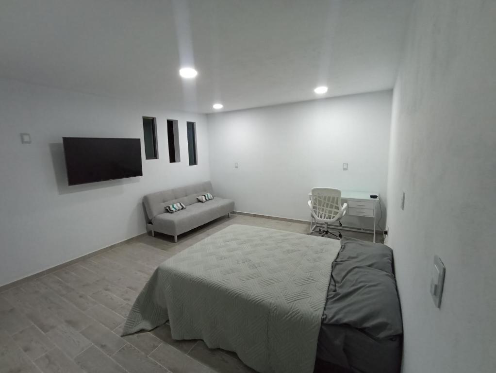 biały pokój z łóżkiem i kanapą w obiekcie Habitación Platino comfort y elegancia en Pachuca 
