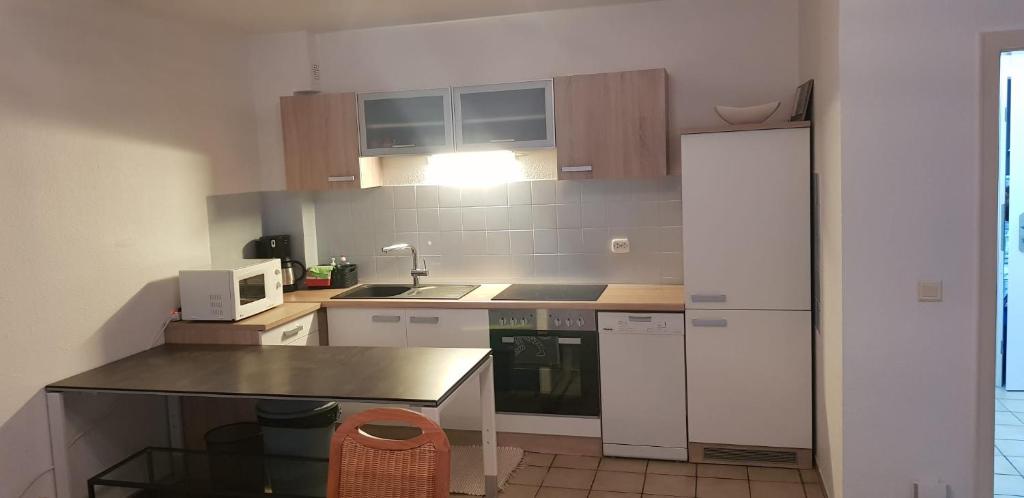 eine kleine Küche mit einem weißen Kühlschrank und einer Theke in der Unterkunft Joanna Apartment - Schwetzingen 2 in Schwetzingen
