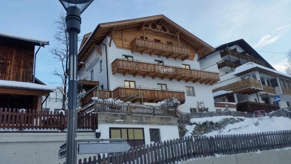 a large white building with a wooden balcony at Apart Tyrol in Serfaus