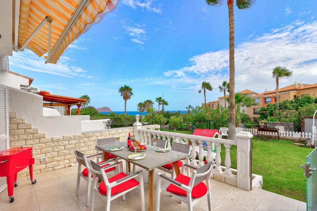 een patio met een tafel en stoelen op een balkon bij Ocean View Duplex Tenerife ( Golf del Sur) in San Miguel de Abona