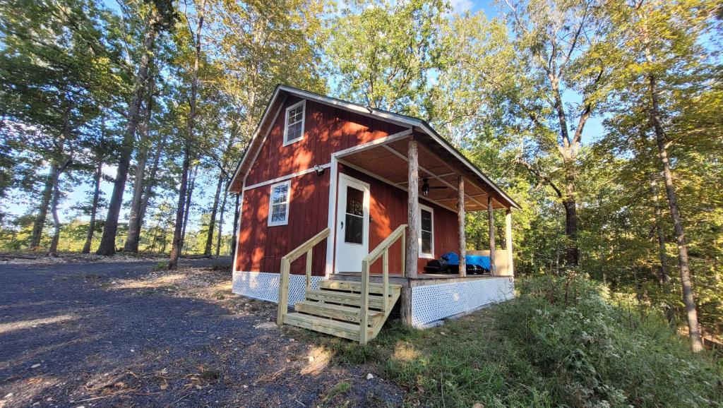 a red tiny house in the woods at The Windstorm Cabin - Pet-friendly & a 2-person Jacuzzi hot tub! in Marshall