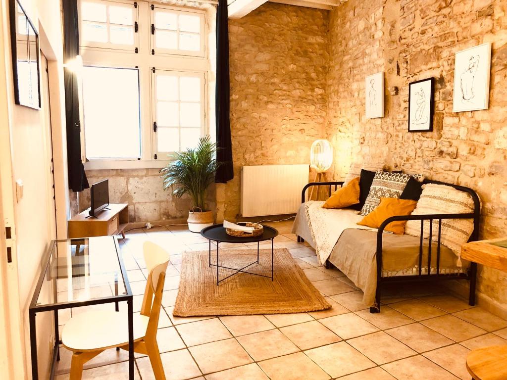 uma sala de estar com um sofá e uma mesa em Le MOKA Charmant Appartement au coeur de ville em Nîmes