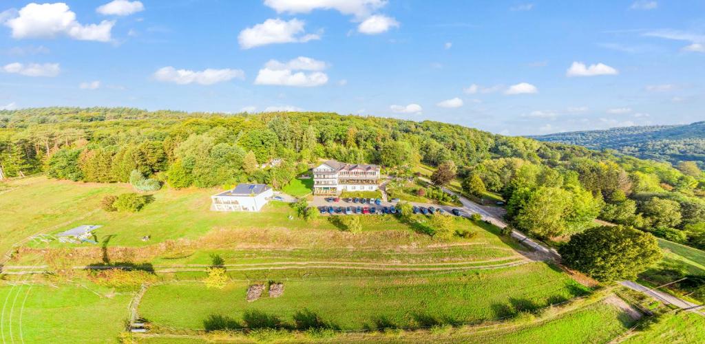 eine Luftansicht eines Hauses auf einem Hügel in der Unterkunft Waldhotel Sonnenberg in Bollendorf