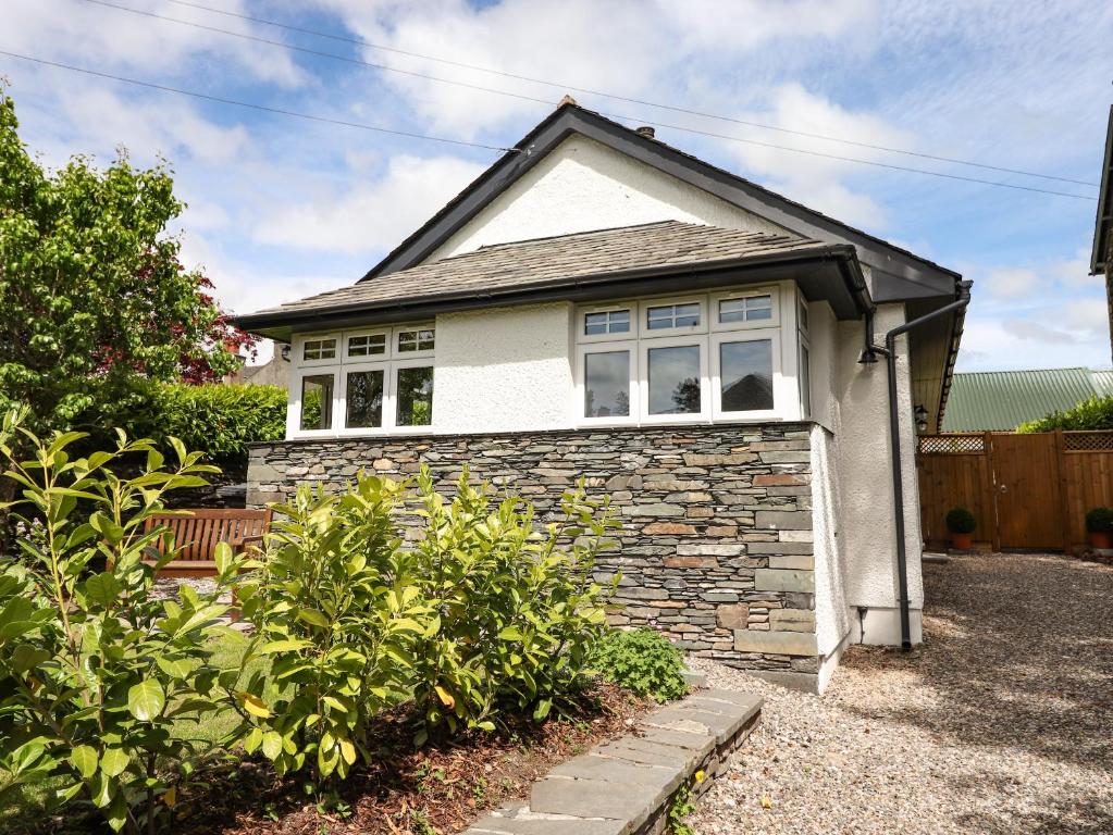 a small white house with a window at Lilac Cottage in Windermere