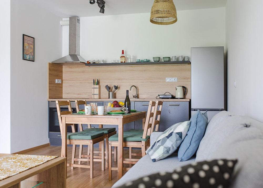 una cucina con tavolo e sedie in una stanza di City and Thermal Apartman a Győr