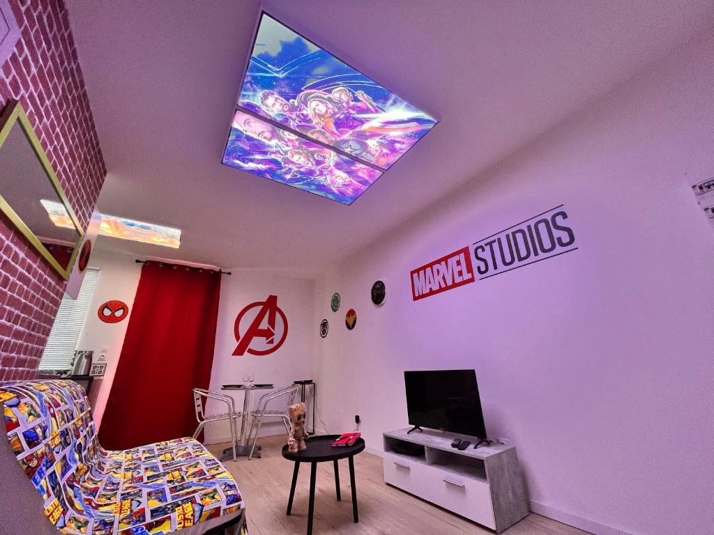 a living room with a video game on the ceiling at Le Marvel - AVENGERS in Bédarieux