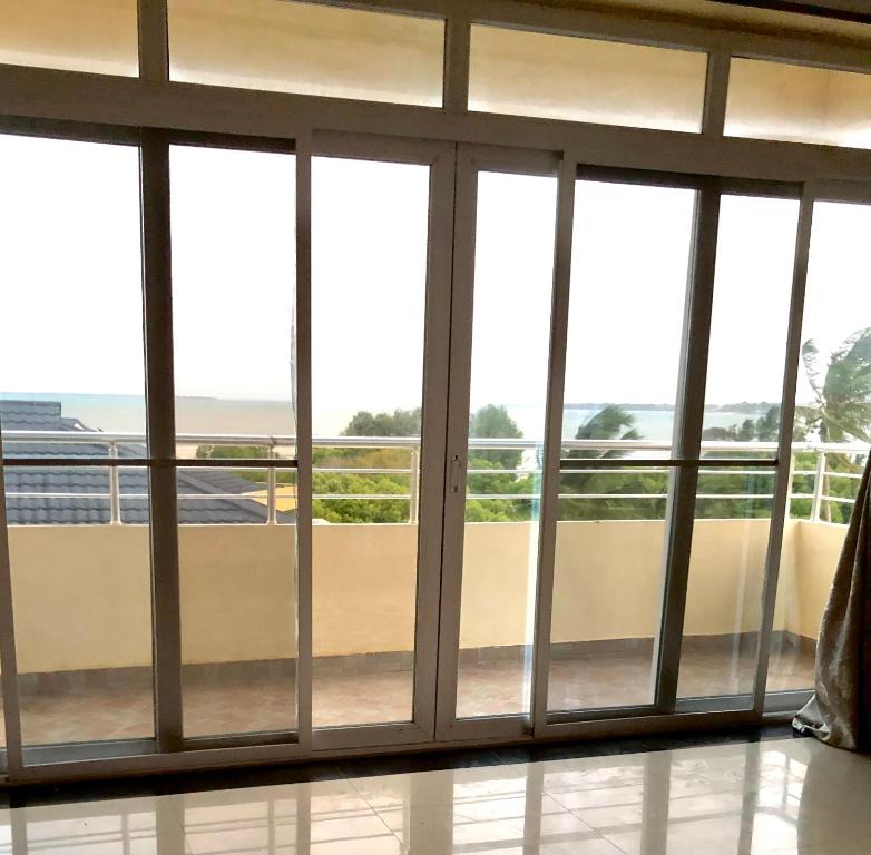 Habitación con puertas correderas de cristal y vistas al océano. en Bay's view, en Dar es Salaam