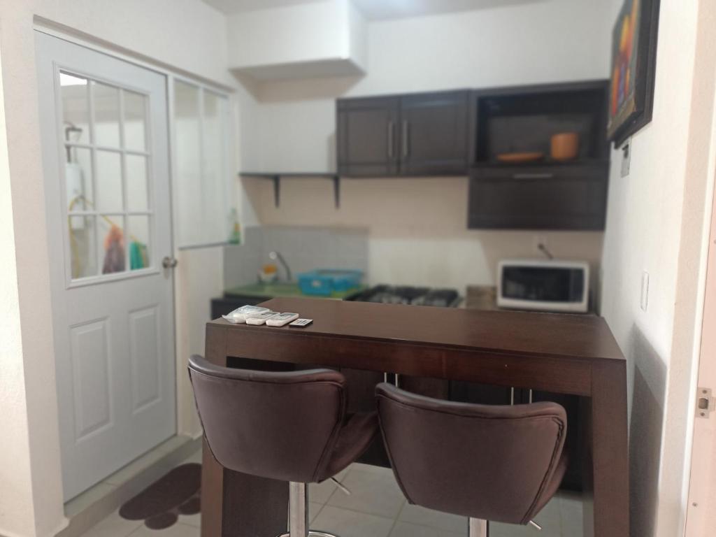a kitchen with a desk and two chairs in a room at Renta departamento por día en Acapulco in Acapulco