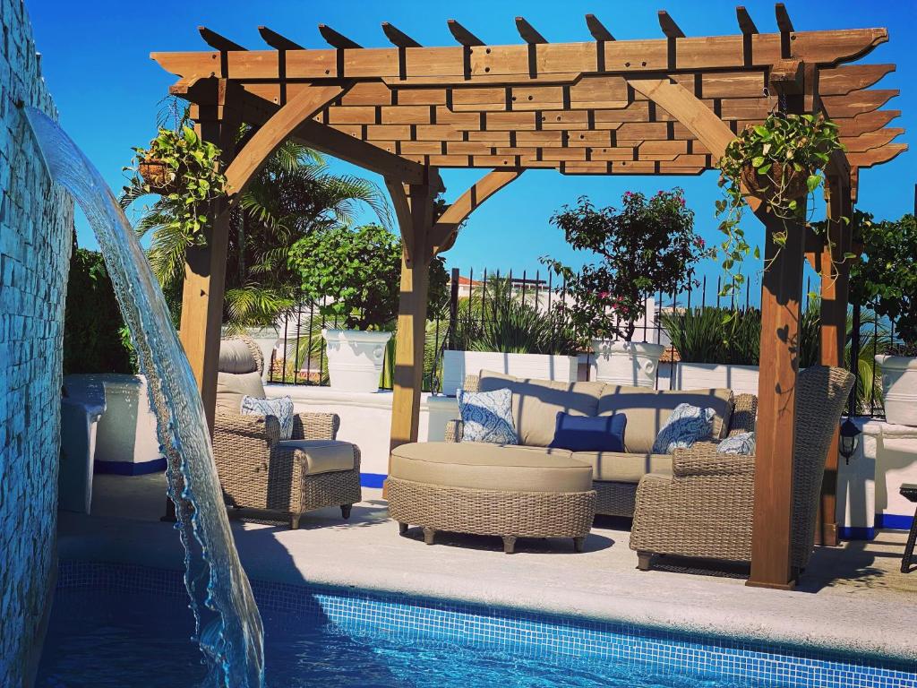プエルト・バジャルタにあるHotel Suites Mar Elenaのプール(椅子付)、スイミングプールの隣のパーゴラを利用できます。