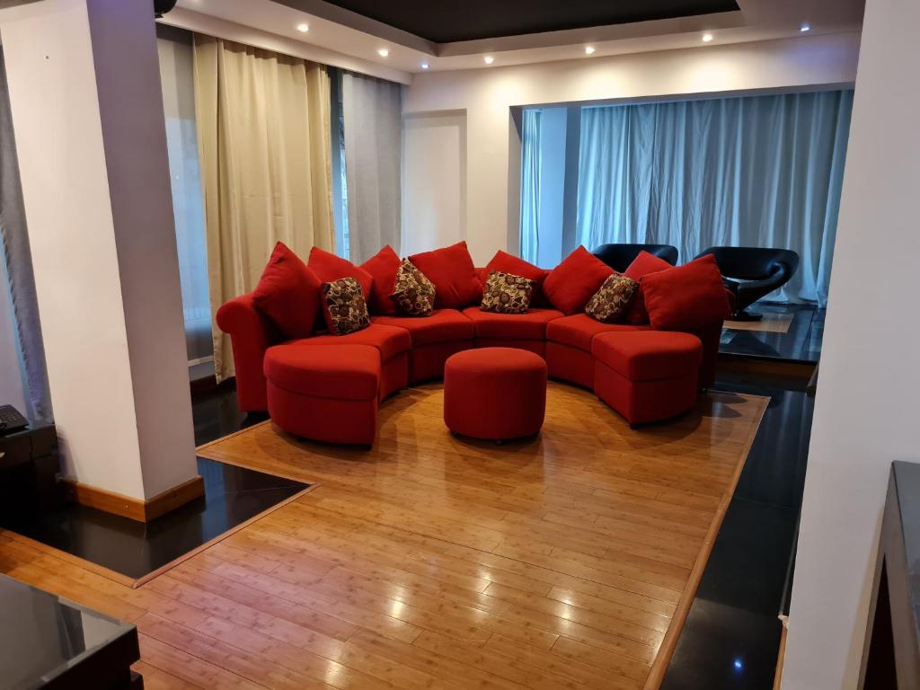 a living room with a red couch and chairs at Relax at Heliopolis in Cairo